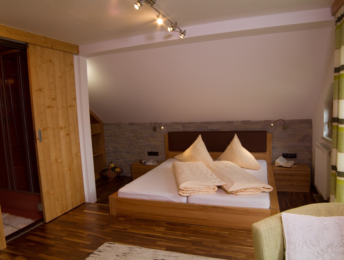 Gemütliches Schlafzimmer mit Doppelbett, Holzmöbeln und warmem Licht